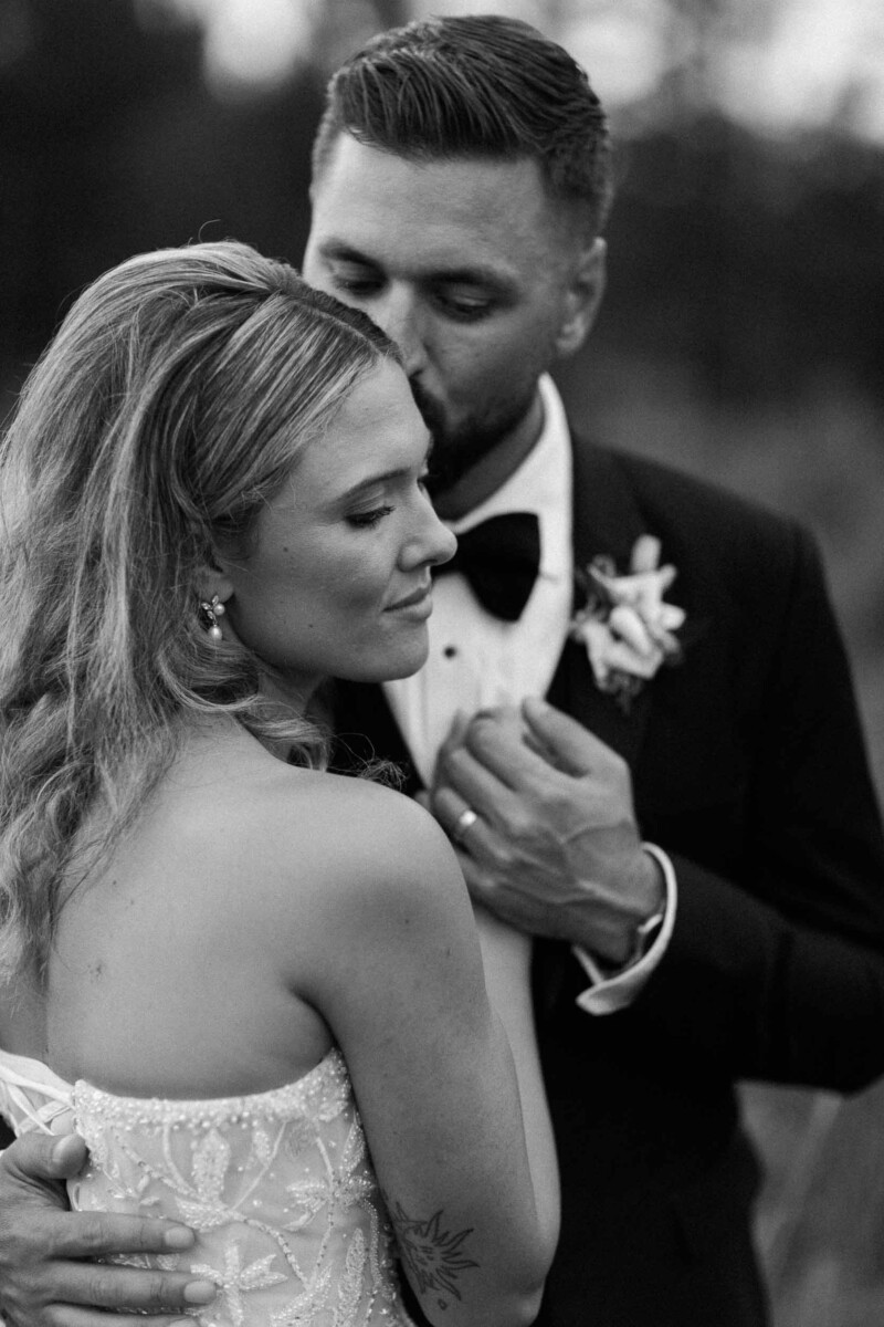 Wedding couple embracing outdoors in black and white.