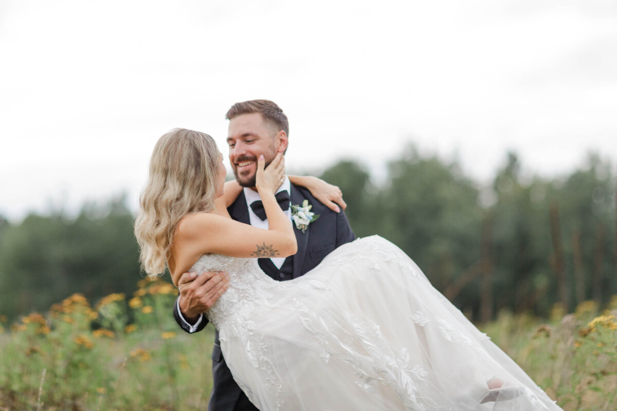 Bride and groom sharing a joyful moment outdoors near Minocqua, WI.