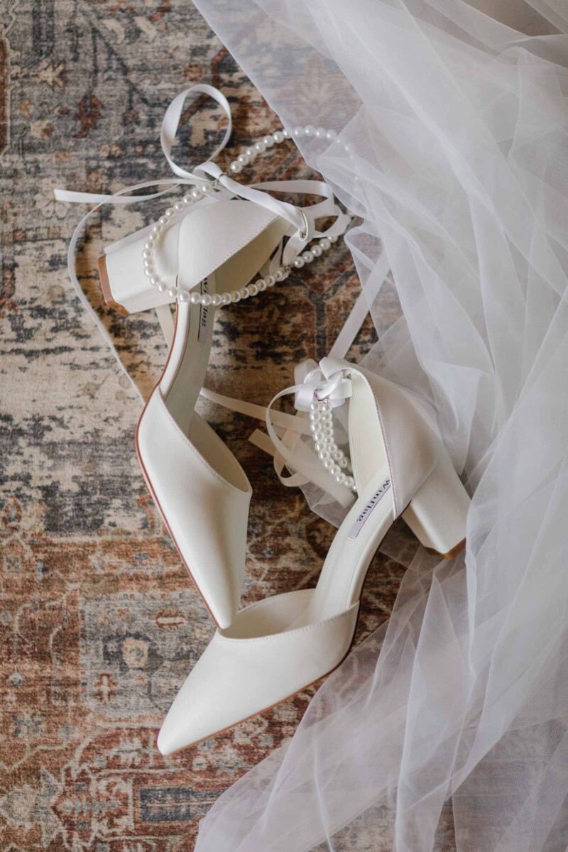 Bridal shoes with pearl accents and ribbons, perfect for a rustic fall wedding.