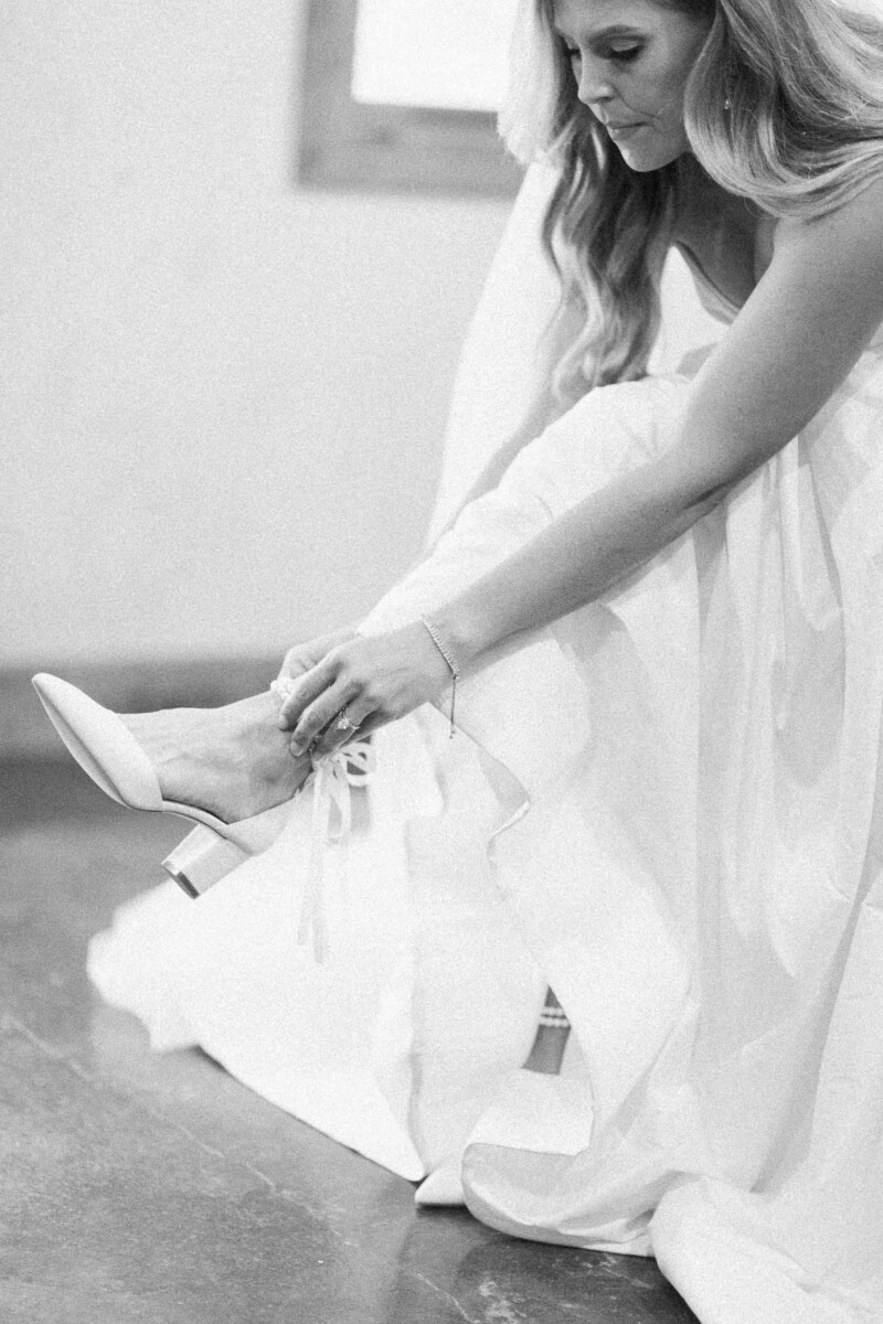 Bride putting on her wedding shoe, preparing for her fall rural Utah wedding.