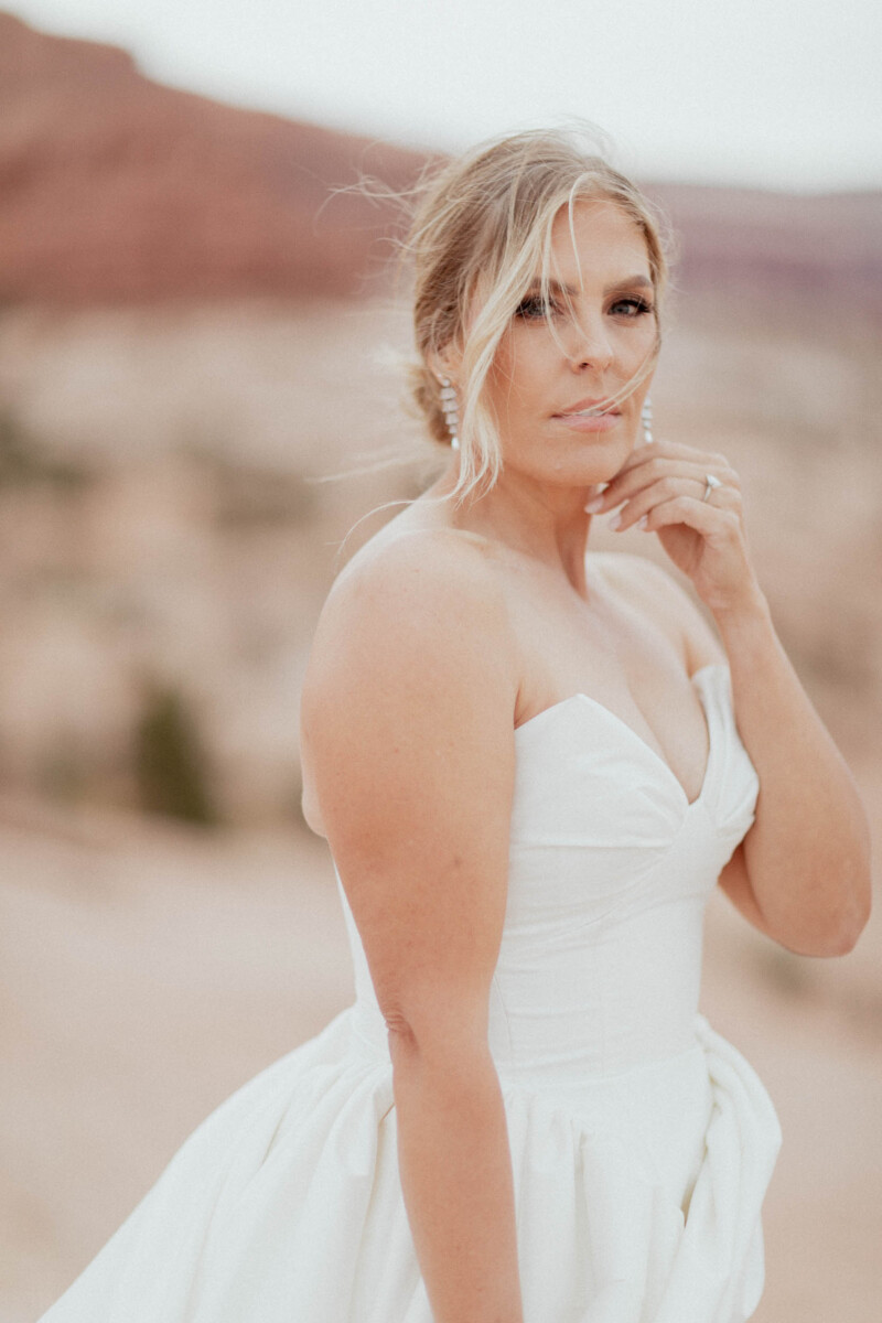 Bride in a white wedding gown with a natural landscape background in Moab, Utah.