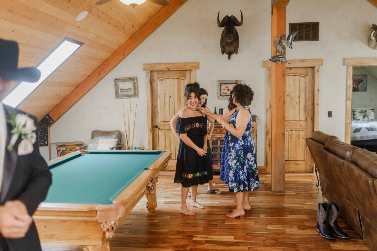 Beautiful moment of two women sharing a joyful conversation at a rustic indoor wedding venue.