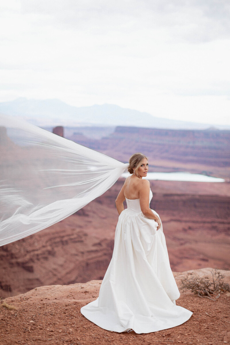 Bride in Moab Utah bridal gown with scenic desert landscape.
