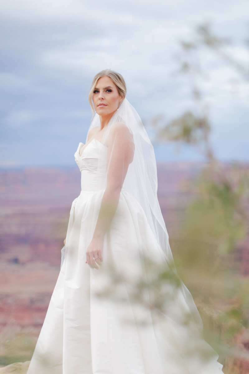 Bride in white wedding dress with veil at Moab Utah canyon.