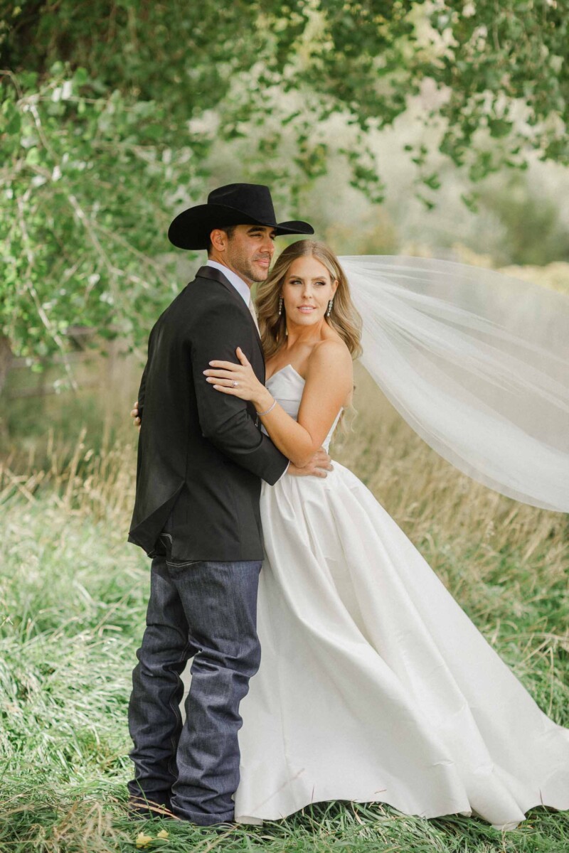 Bride and groom embracing outdoors during fall wedding in Utah.