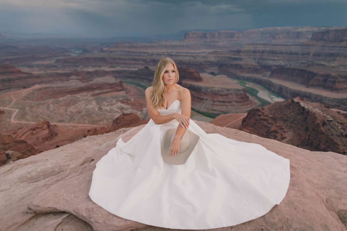 Bridal portrait of a bride in a white gown at Moab Utah with Grand Canyon background.
