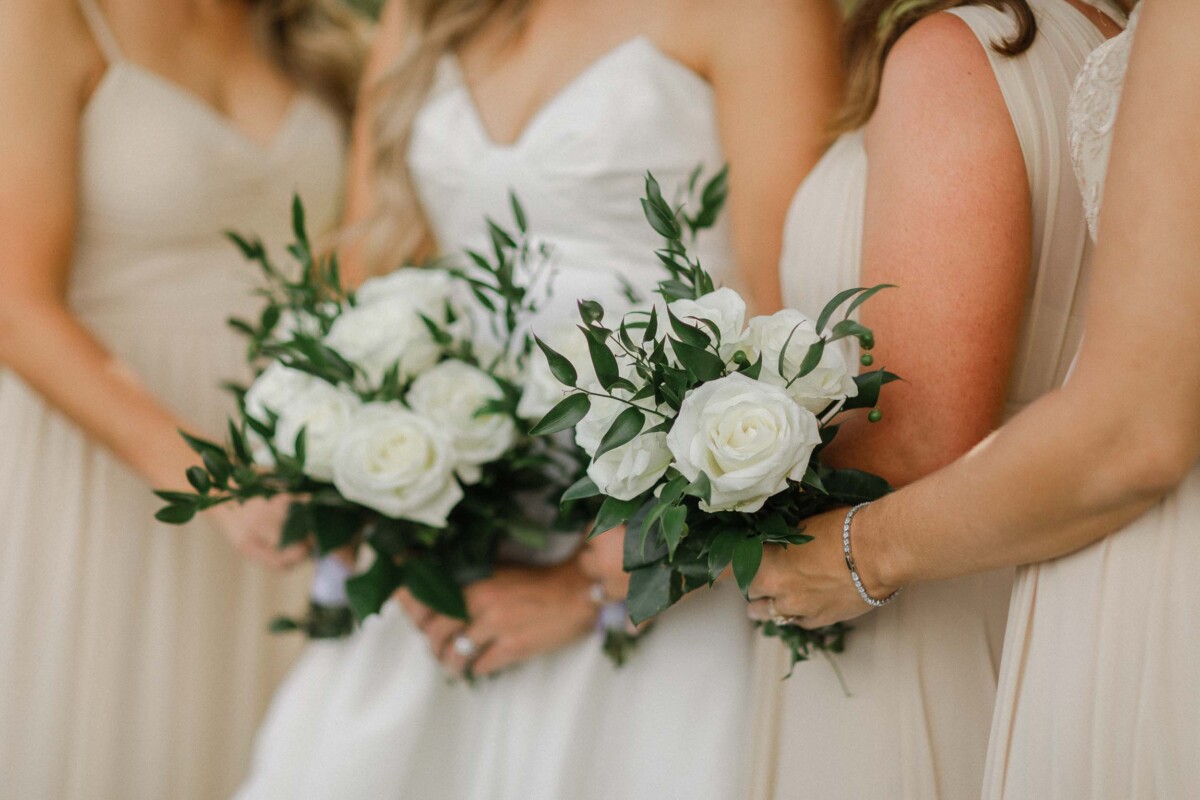 Brides holding beautiful white roses and greenery bouquets during a private fall wedding in Utah.
