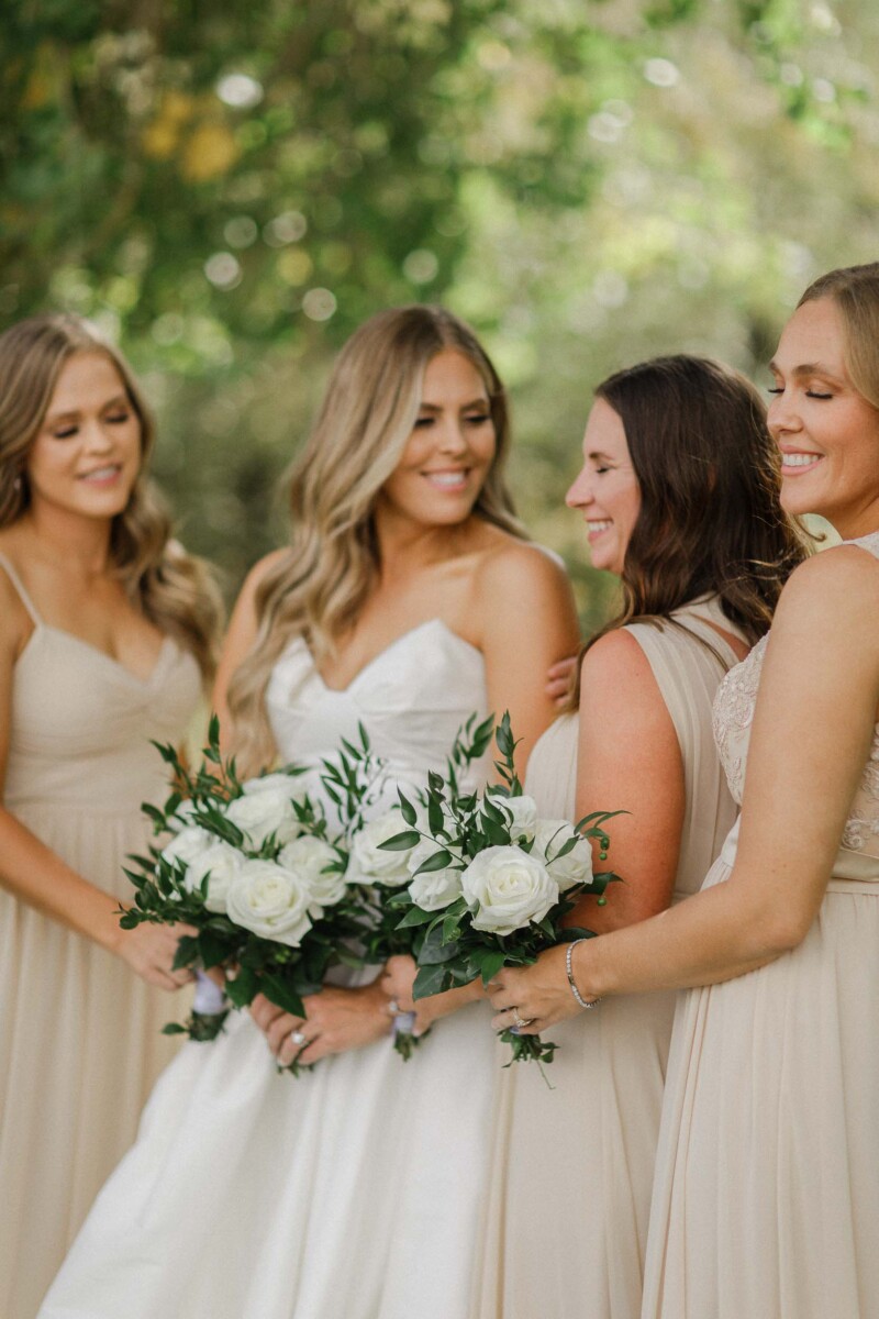 Bridesmaids and bride sharing a joyful moment outdoors at a rural Utah wedding.