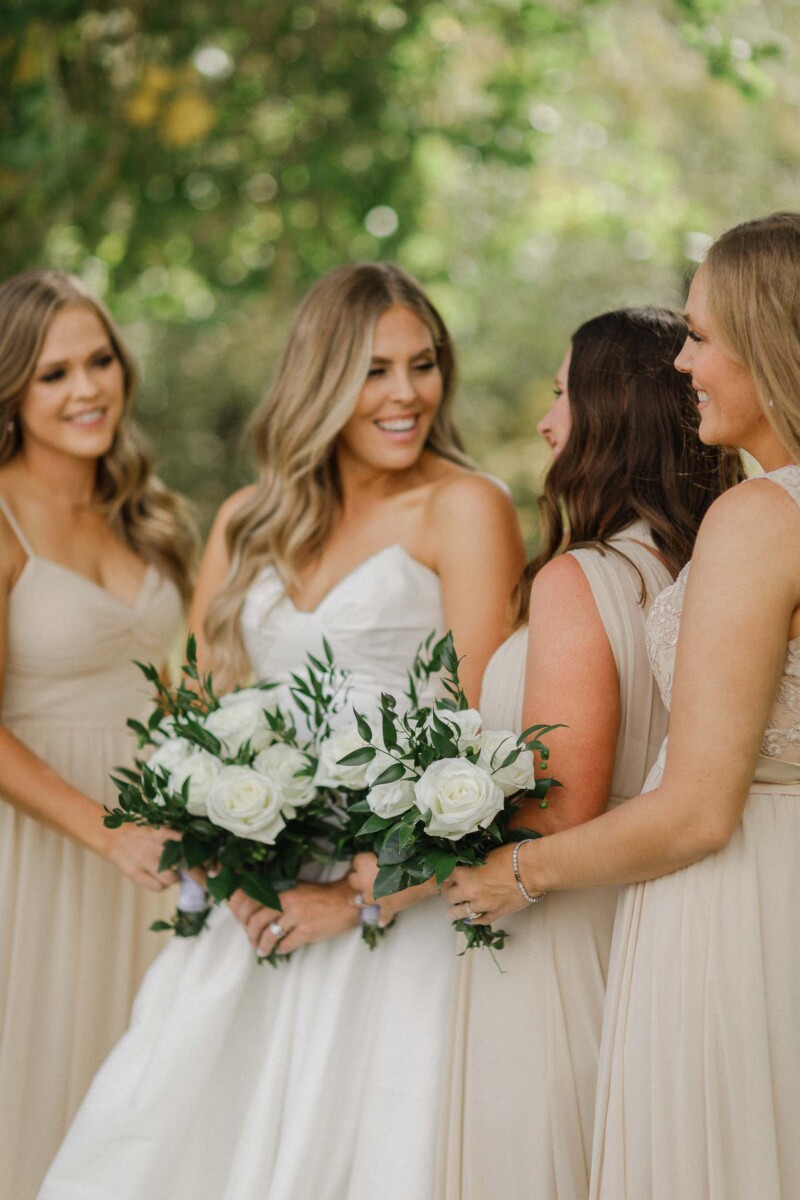 Bridesmaids and bride sharing a joyful moment outdoors during a Utah fall wedding.