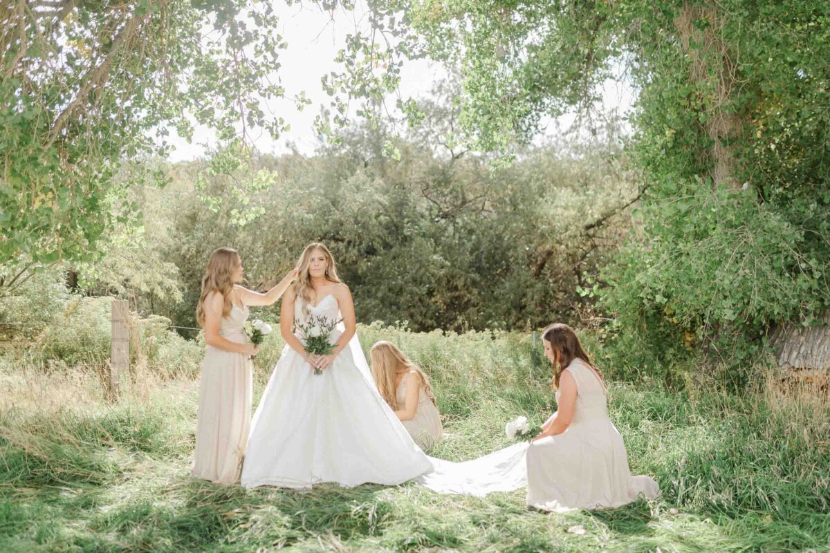 Bride and bridesmaids in a lush outdoor setting during a Utah fall wedding.