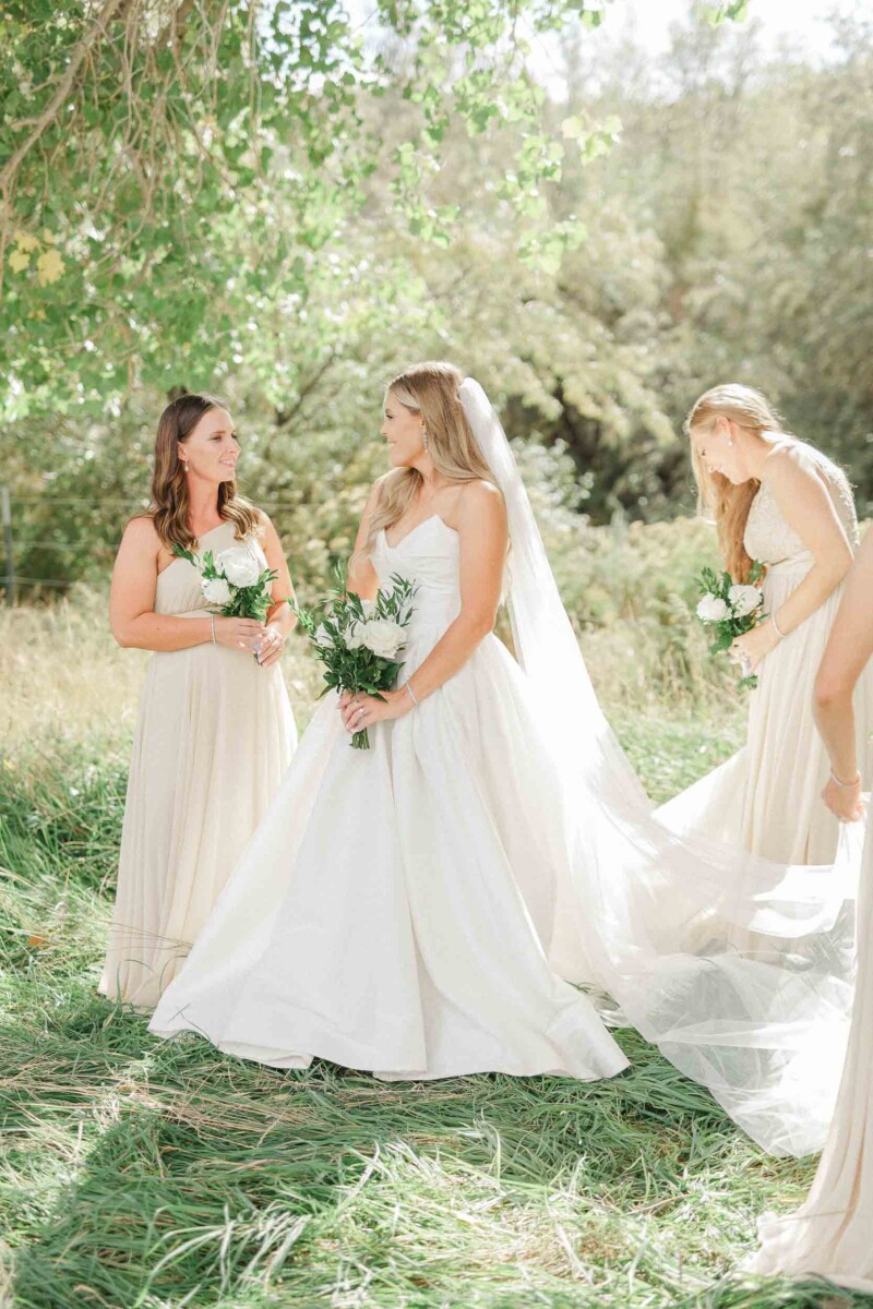 Bride and bridesmaids in a scenic outdoor setting during a fall wedding.
