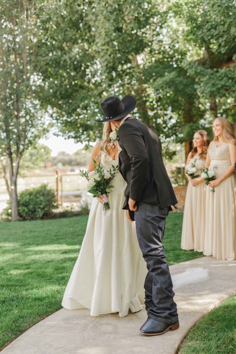 Bride and groom share a kiss during their rustic Utah fall wedding.