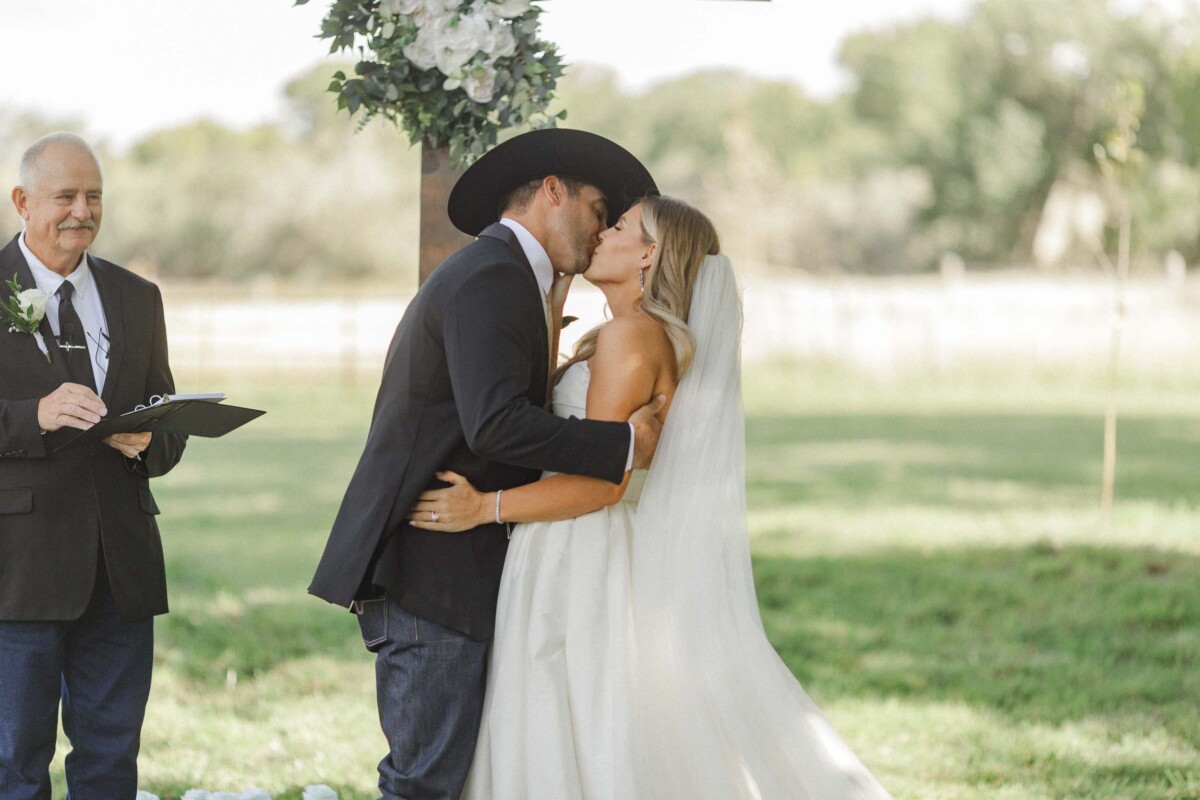 Bride and groom sharing a kiss during their outdoor Utah fall wedding ceremony.