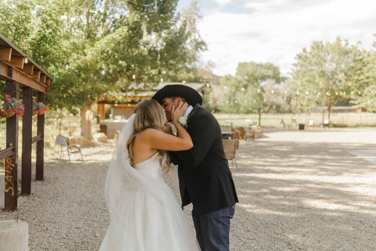 Bride and groom sharing a kiss outdoors during a rustic Utah fall wedding.