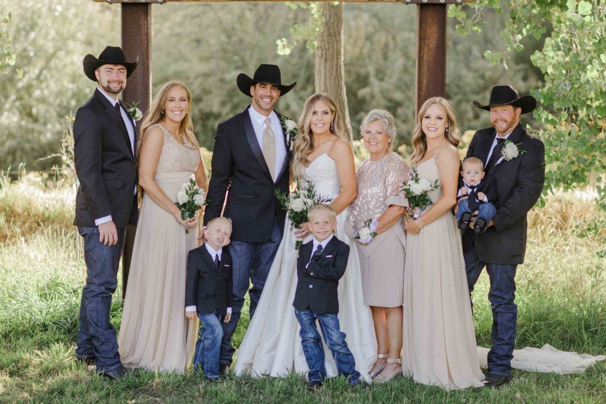 Wedding group portrait at a rural outdoor setting.