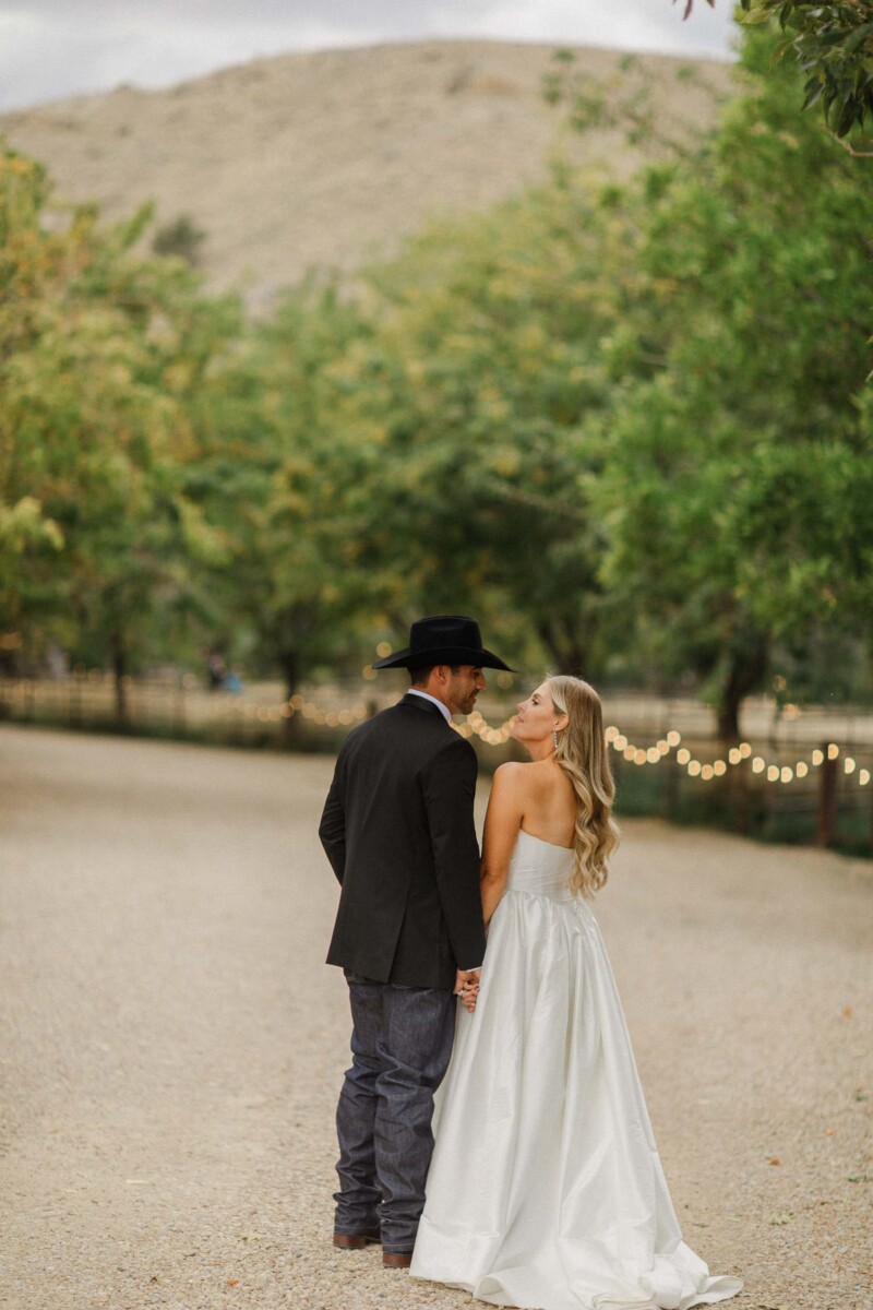 Wedding couple sharing a kiss outdoors in a natural setting.