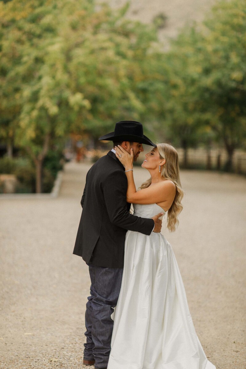 Romantic couple portrait of Sean and Davie embracing outdoors during their fall wedding in rural Uta.