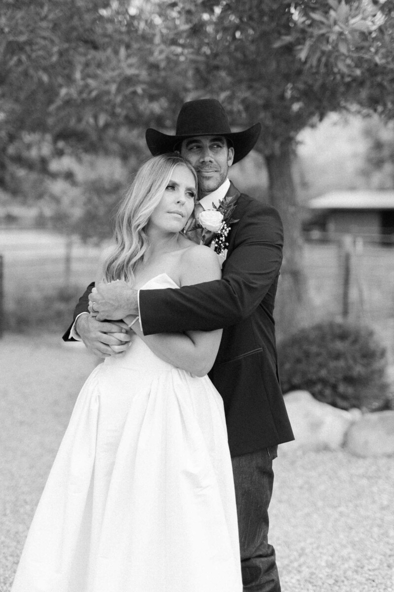 Wedding couple embracing outdoors in black and white.