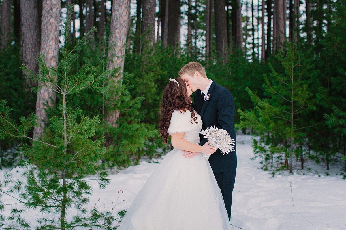 Rothchild Pavilion winter wedding bride and groom kissing in pine trees