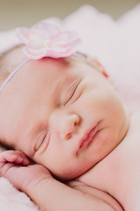 sleeping newborn with pink flower on head photo