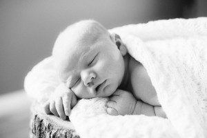 sleeping newborn on log
