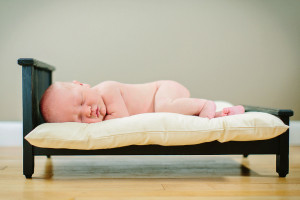 newborn on minature bed photo