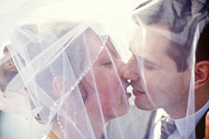 Bride and Groom kissing under veil