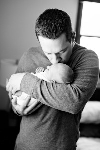 Dad holding baby by window