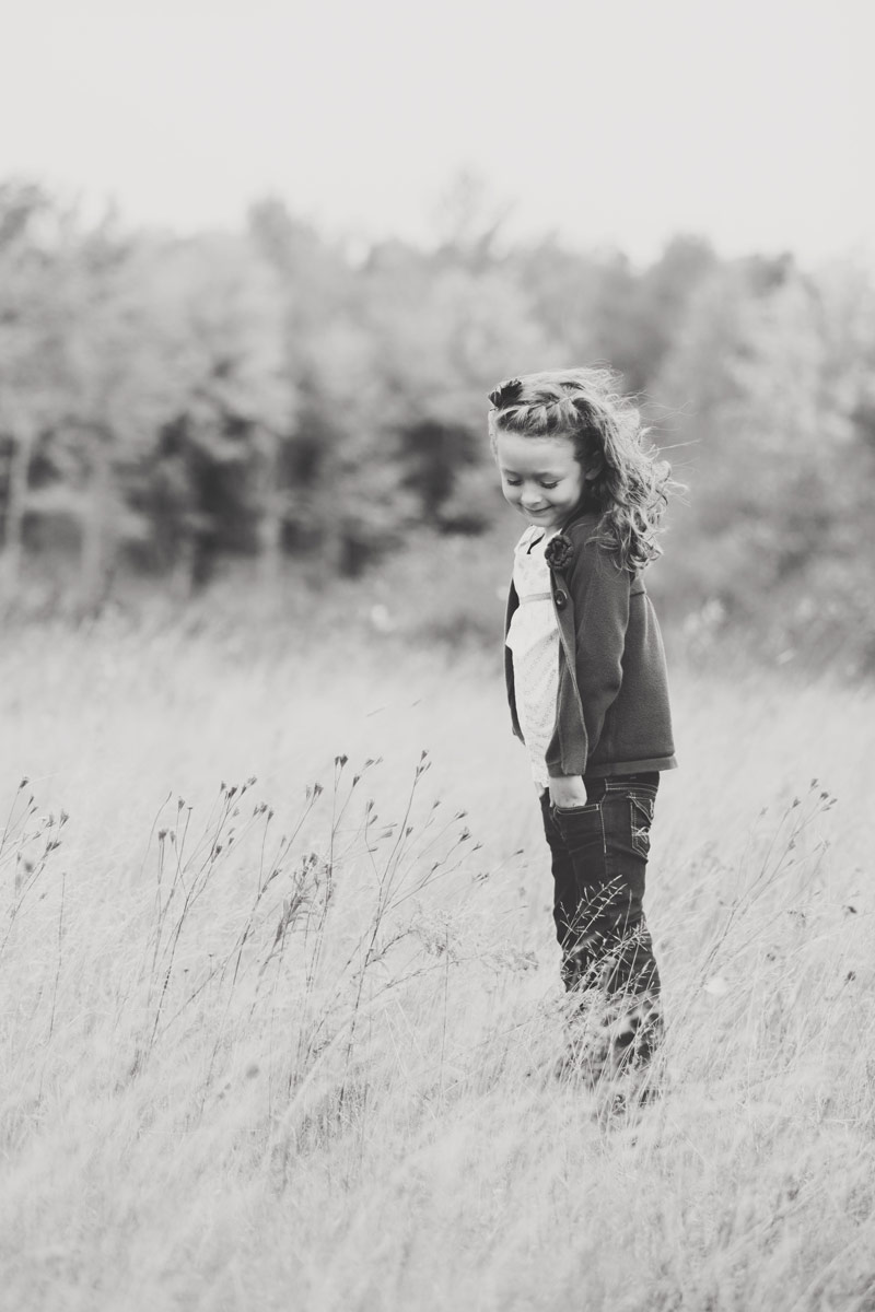 girl in field with wind blowing in wind photo
