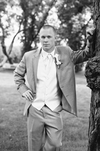Groom standing by a tree