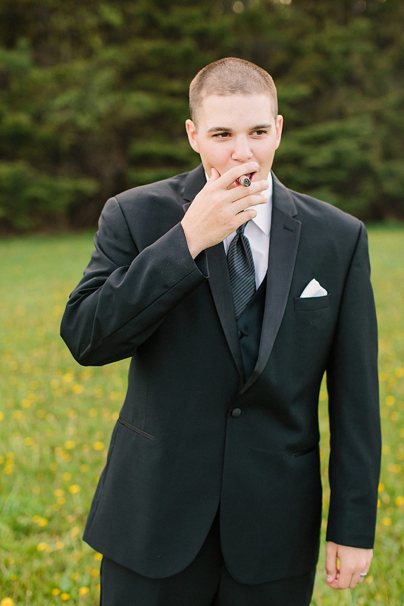 groom smoking a cigar at wedding photo