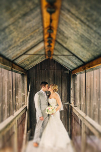 enchanted barn wedding photos of bride and groom on bridge