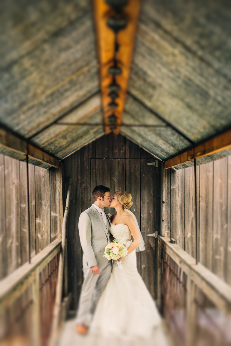 enchanted barn wedding photos of bride and groom on bridge