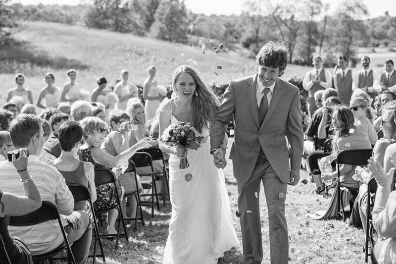 bride and groom walking down aisle with flowers thrown 