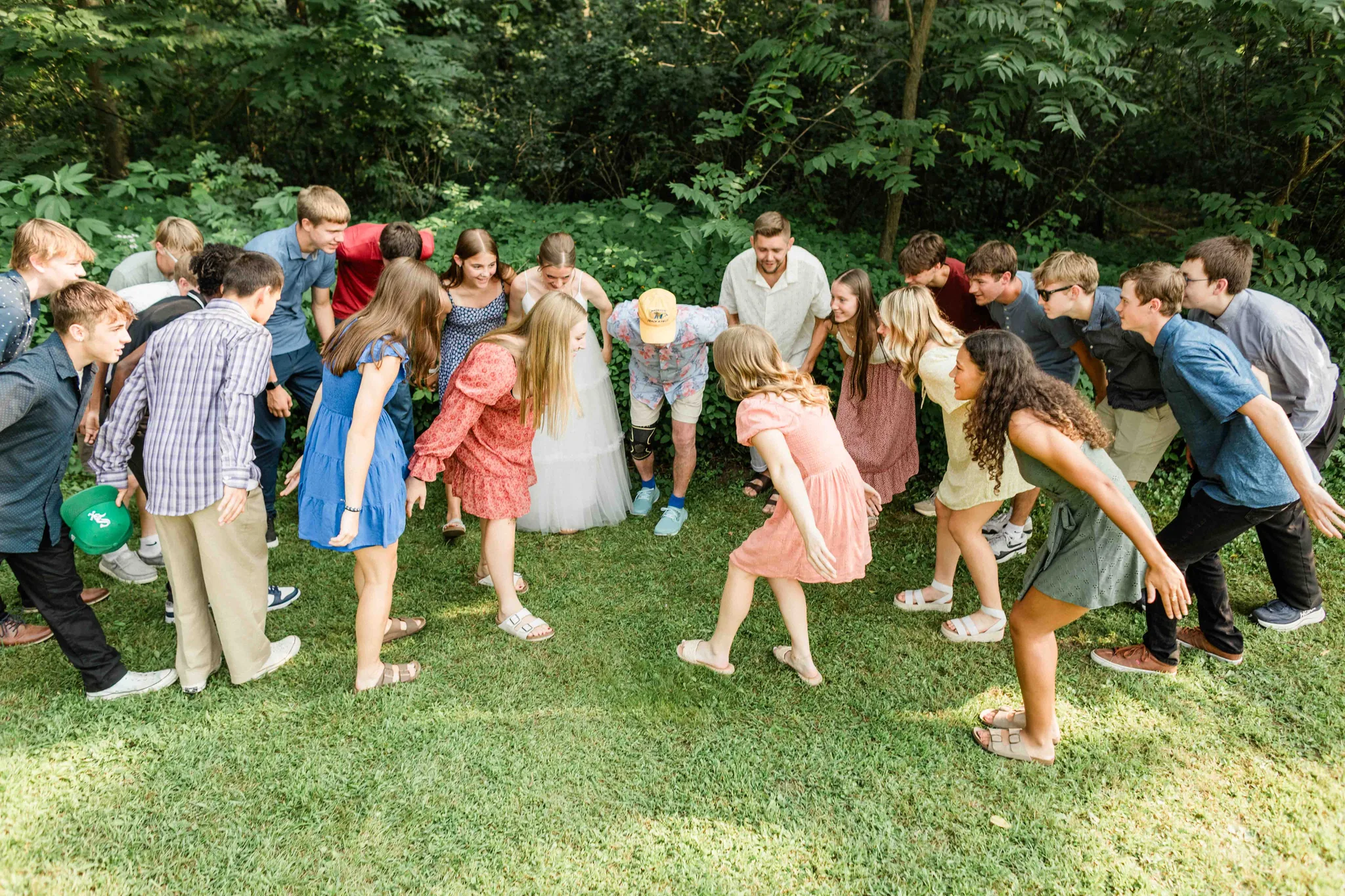 Wedding guests surrounding couple in circle lawn game at Wisconsin Dells backyard wedding reception