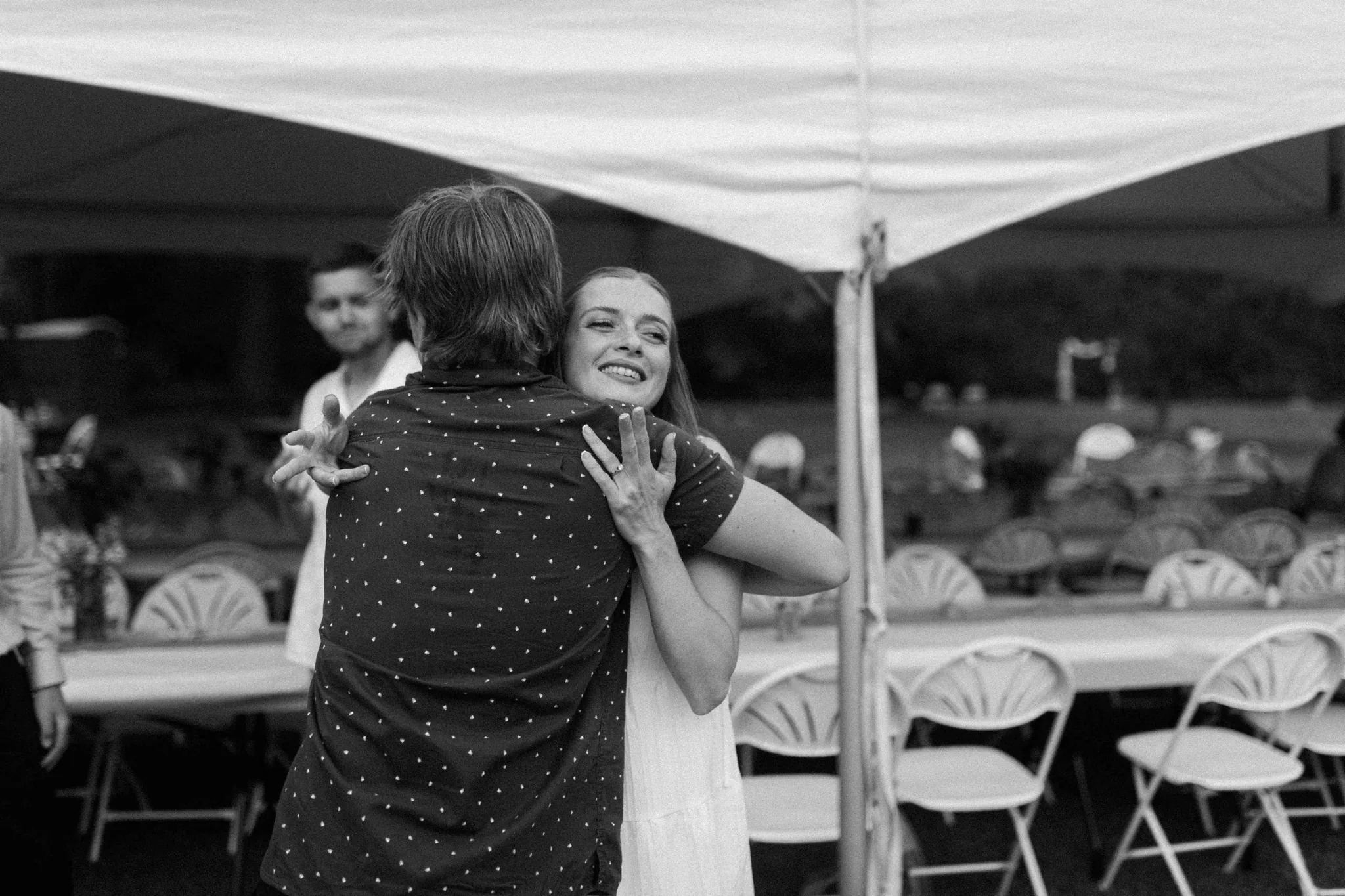 Black and white photo of guests dancing under tent at late night Wisconsin Dells backyard wedding reception