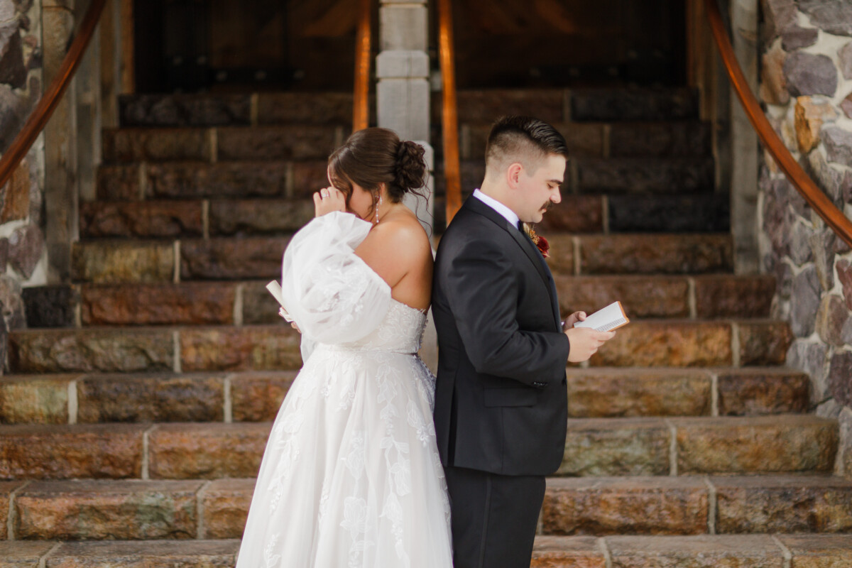 Bride and groom standing back to back on the stone stairs for a no-look vow reading