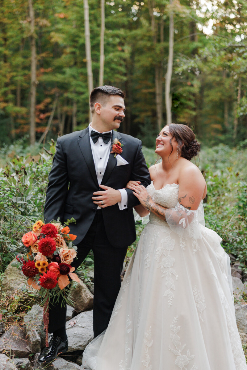 Bride and groom laughing together among birch trees at golden hour