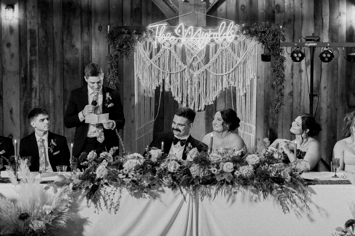 Black and white photo of a toast during speeches at the head table