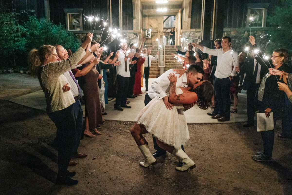 Groom dipping the bride for a final kiss during the sparkler send-off